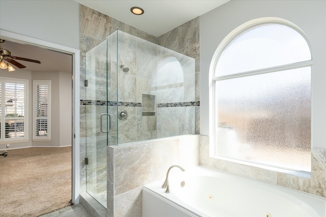 bathroom with a stall shower, a ceiling fan, a tub with jets, and plenty of natural light