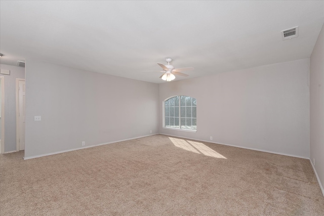 empty room with baseboards, ceiling fan, visible vents, and carpet flooring