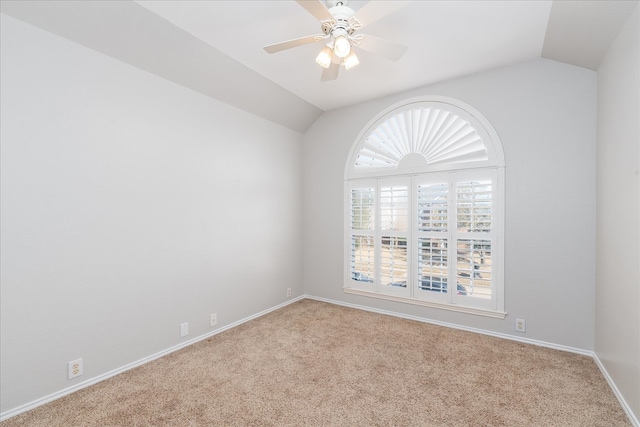 empty room with carpet flooring, ceiling fan, lofted ceiling, and baseboards
