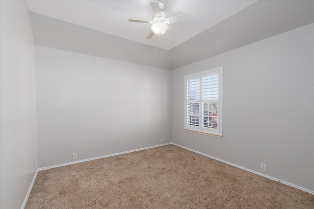 carpeted spare room featuring a ceiling fan and baseboards