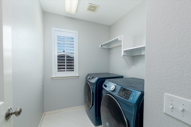 washroom with laundry area, washing machine and clothes dryer, visible vents, and baseboards