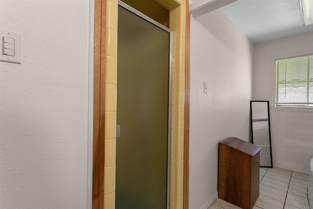 full bathroom with a stall shower and tile patterned flooring