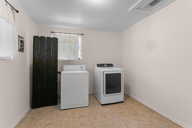 laundry area with laundry area, visible vents, baseboards, and washing machine and clothes dryer