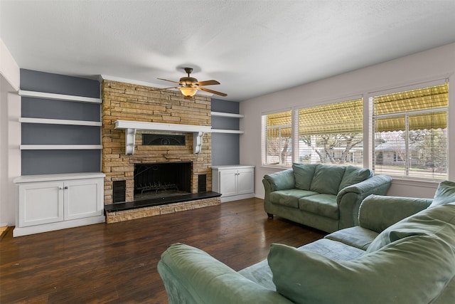 living area with a textured ceiling, a stone fireplace, wood finished floors, and a wealth of natural light