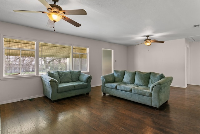 living room featuring attic access, visible vents, baseboards, ceiling fan, and wood-type flooring