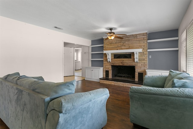 living area with a fireplace, wood finished floors, visible vents, and a ceiling fan