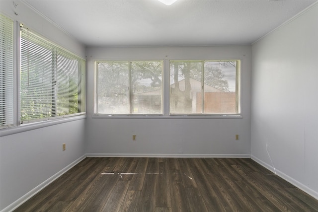 unfurnished room with crown molding, baseboards, and wood finished floors