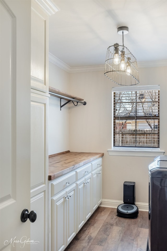 washroom with washer / dryer, baseboards, ornamental molding, and wood finished floors