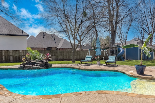 view of pool featuring a playground, a fenced backyard, a yard, a fenced in pool, and a patio area