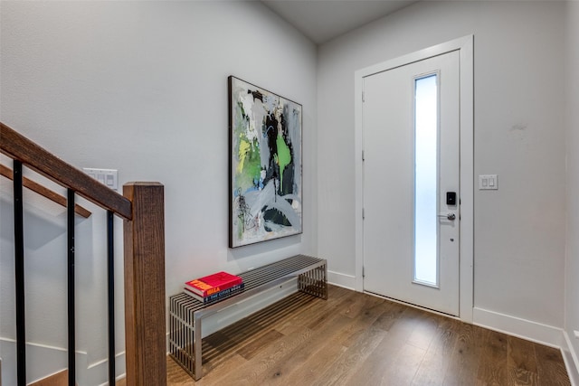 foyer entrance featuring stairs, baseboards, and wood finished floors