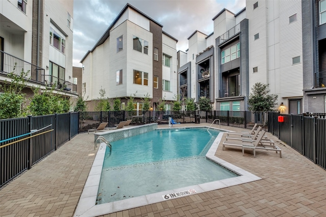 pool with a patio and fence