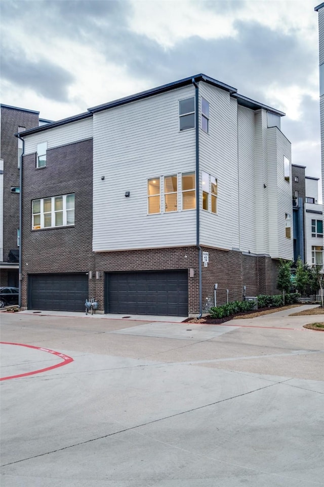 exterior space featuring a garage and brick siding