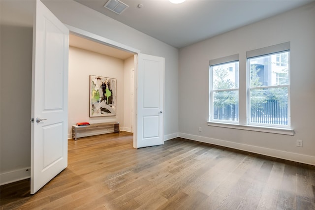 unfurnished bedroom featuring light wood-style floors, baseboards, and visible vents