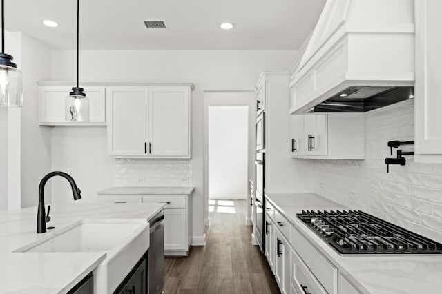 kitchen featuring gas cooktop, a sink, white cabinetry, dishwasher, and custom range hood