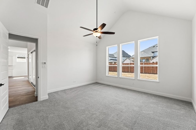 empty room with baseboards, visible vents, a ceiling fan, carpet flooring, and high vaulted ceiling