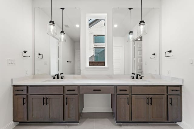 full bath featuring double vanity, baseboards, and a sink