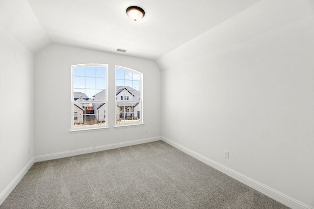 unfurnished room with carpet, vaulted ceiling, and baseboards