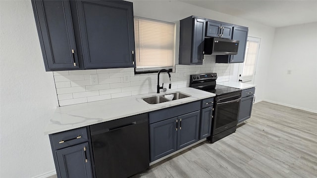 kitchen featuring light wood finished floors, tasteful backsplash, appliances with stainless steel finishes, a sink, and baseboards