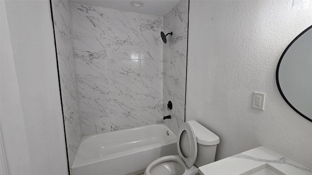 bathroom featuring shower / washtub combination, a textured wall, vanity, and toilet