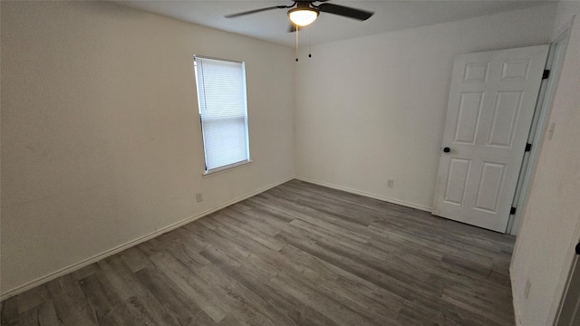 unfurnished room featuring ceiling fan, wood finished floors, and baseboards