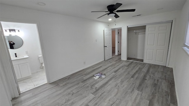 unfurnished bedroom featuring a closet, visible vents, baseboards, and wood finished floors