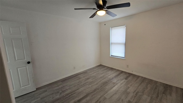 unfurnished room with dark wood-style floors, baseboards, and a ceiling fan