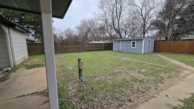 view of yard featuring a fenced backyard, an outdoor structure, and a storage shed