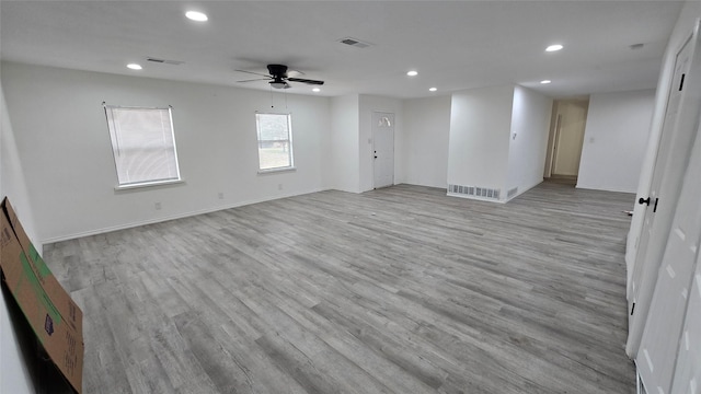 unfurnished room with light wood-type flooring, visible vents, baseboards, and recessed lighting