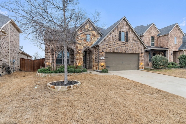 view of front of home with stone siding, brick siding, concrete driveway, and fence