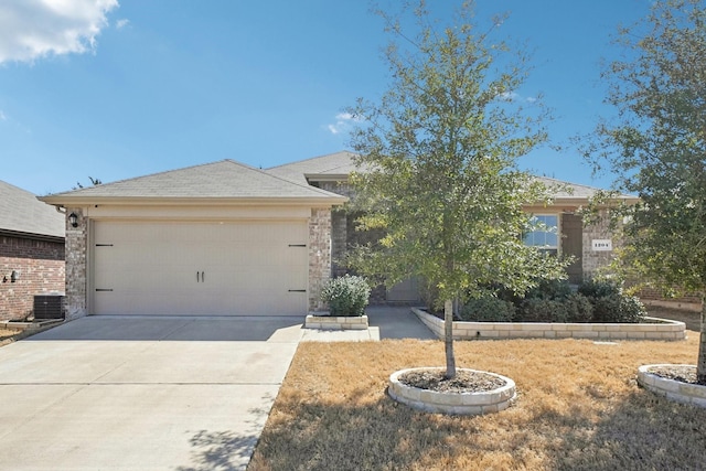 view of front of house with a garage, driveway, and cooling unit