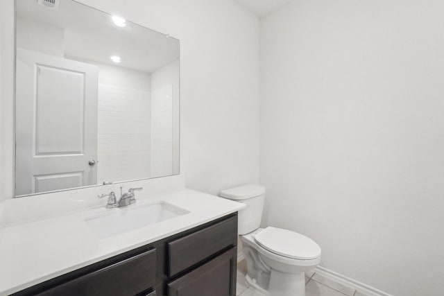 bathroom featuring baseboards, visible vents, toilet, tile patterned floors, and vanity