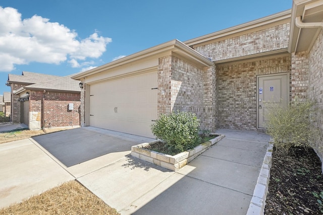 view of property exterior featuring concrete driveway, brick siding, and an attached garage