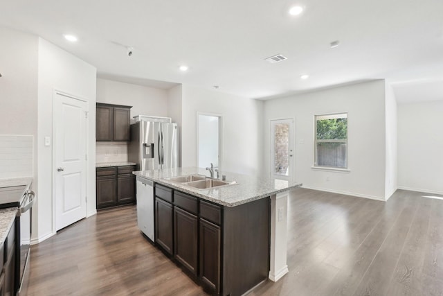 kitchen with dark brown cabinetry, dark wood-style flooring, a sink, visible vents, and appliances with stainless steel finishes