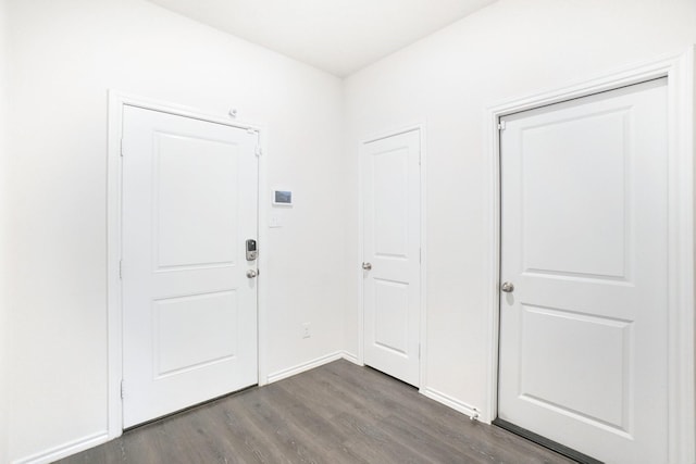 foyer entrance featuring baseboards and dark wood finished floors