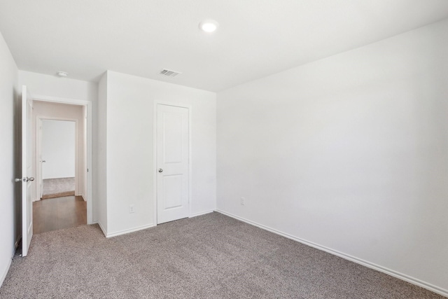 unfurnished bedroom featuring carpet flooring, visible vents, and baseboards