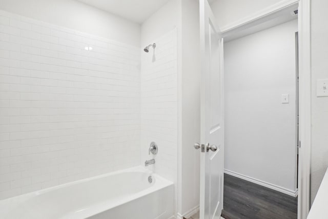 full bathroom featuring shower / bath combination, baseboards, and wood finished floors