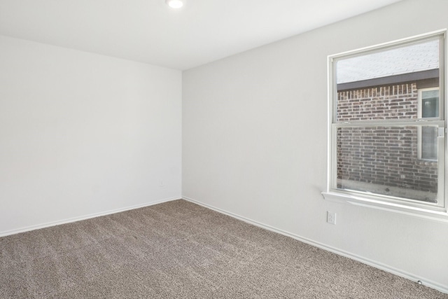 carpeted empty room with baseboards