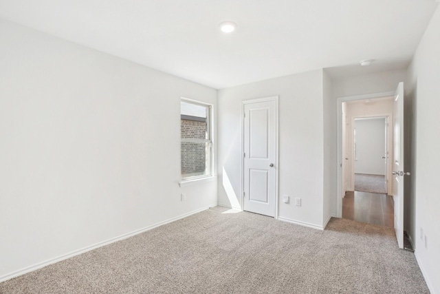 unfurnished bedroom featuring carpet and baseboards