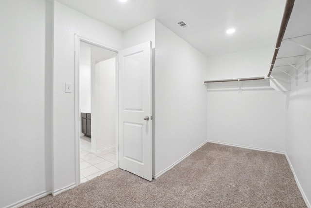 walk in closet featuring light carpet and visible vents