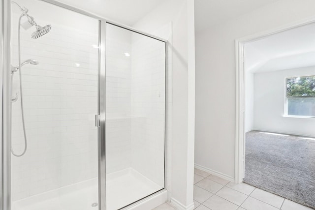 bathroom with a stall shower, baseboards, and tile patterned floors