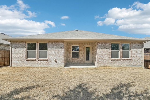 rear view of property featuring fence and brick siding