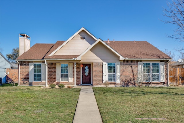 view of front facade featuring brick siding, a chimney, a shingled roof, fence, and a front lawn