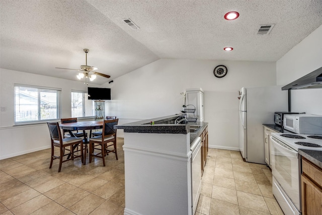 kitchen featuring lofted ceiling, white appliances, dark countertops, and visible vents