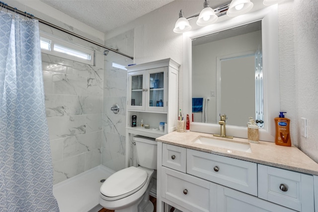 bathroom featuring a textured wall, toilet, a textured ceiling, vanity, and tiled shower