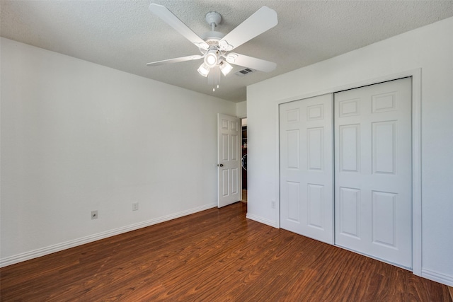 unfurnished bedroom featuring visible vents, a textured ceiling, baseboards, and wood finished floors