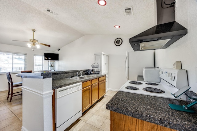 kitchen with lofted ceiling, white appliances, a sink, visible vents, and wall chimney exhaust hood