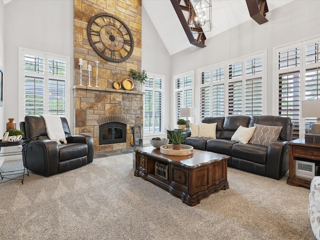 carpeted living area with high vaulted ceiling, a chandelier, and a fireplace