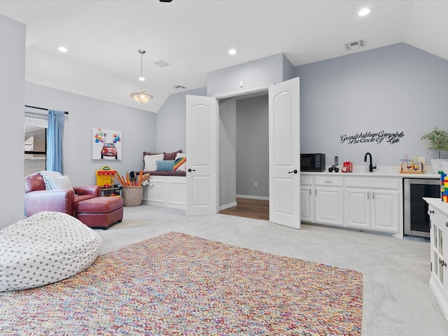 bedroom with wine cooler, light carpet, a sink, vaulted ceiling, and indoor wet bar