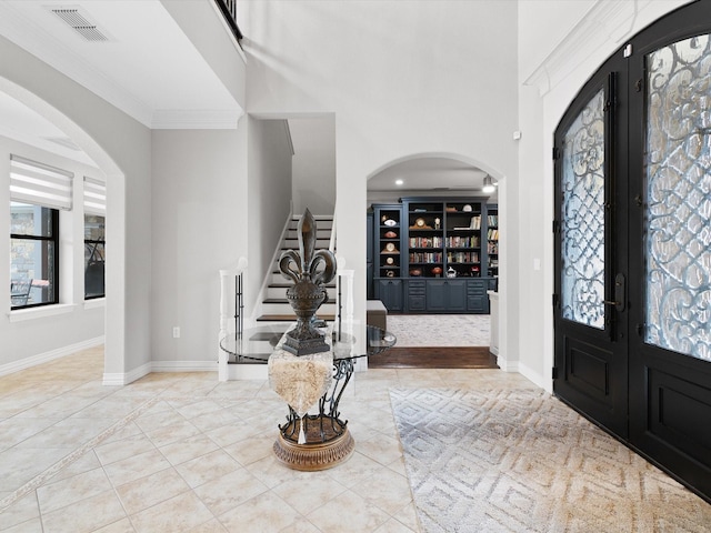 tiled entryway featuring visible vents, baseboards, stairs, french doors, and a wealth of natural light