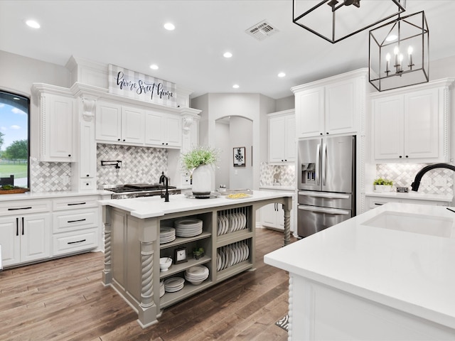 kitchen with open shelves, light countertops, visible vents, appliances with stainless steel finishes, and a sink